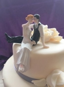 Bride and groom sitting on the side of cake