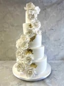 Tall elegant wedding cake with gold leaf and sugar flowers 