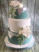 green and white wedding cake with silver leaf