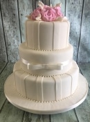 wedding cake with icing stripes and roses