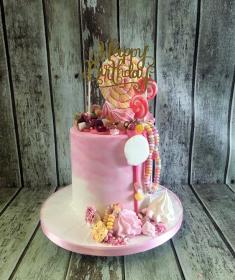 chocolate drip cake with sweets and merangues birthday cake