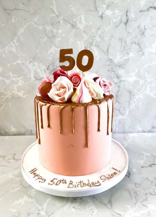 Drip style birthday cake with sugar flowers and meringues