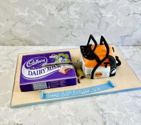 chainsaw birthday cake with big Dairy milk bar of chocolate made of cake