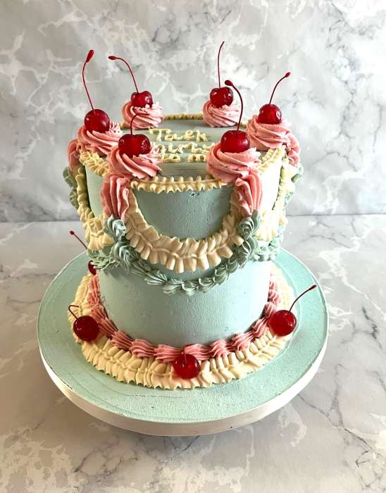 buttercream-birthday-cake-with-over-piping-and-cherries