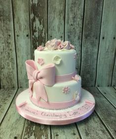 girls with sugar bow christening cake