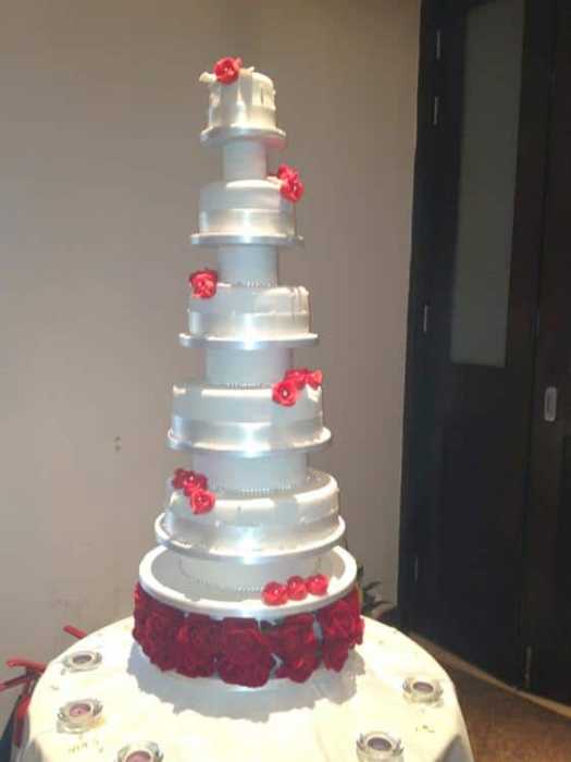Extra large wedding cake adorned with  silver  hand painting and sugar  flowers