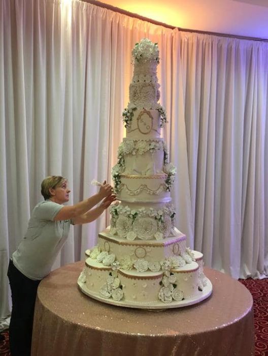 Extra large wedding cake adorned with  gold hand painting and sugar  flowers   Price on application