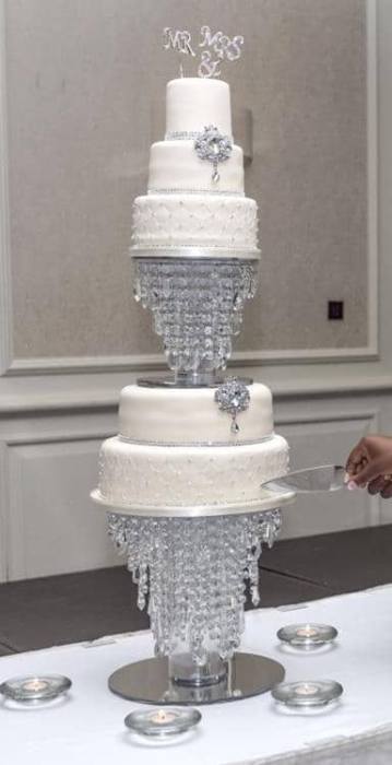 Extra large wedding cake adorned with  diamante  Brooches and studs standing on a crystal stand