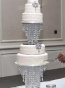 Extra large wedding cake adorned with  diamante  Brooches and studs standing on a crystal stand