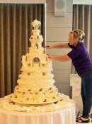 Extra large wedding cake adorned with cherups and gold hand painting sand silk flowers 