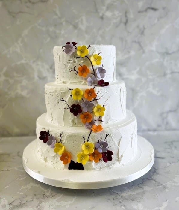 Rustic buttercream wedding cake with a hand painted blossom tree and sugar blossom  had made flowers
