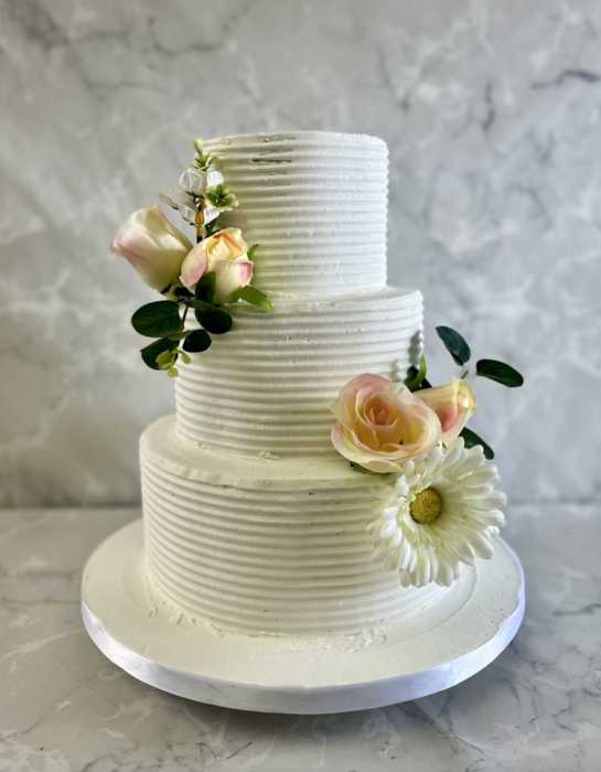 Fine lines buttercream wedding cake with silk flowers