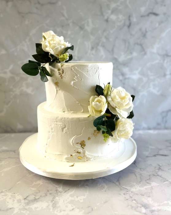 2 tier Rustic buttercream wedding cake with silk flowers and gold leaf