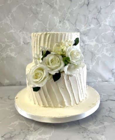 2 tier buttercream wedding cake with silk flowers
