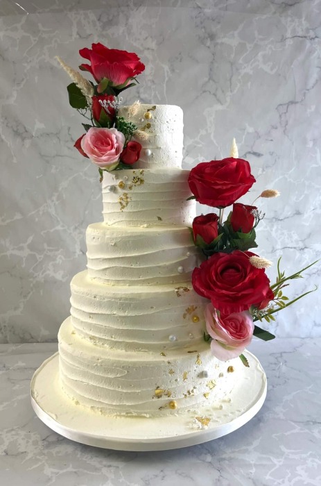 buttercream-wedding-cakle-and-pik-and-red-silk-flowers-wedding-cake