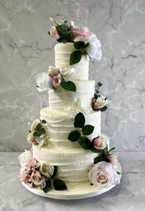 pink-combed-buttercream-with-a-seection-of-pink-silk-flowers-wedding-cake