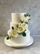 3 tier frosting wedding  cake with cascading silk flowers 