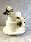 2 tier Rustic buttercream wedding cake with silk flowers and gold leaf 