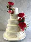 buttercream-wedding-cakle-and-pik-and-red-silk-flowers-wedding-cake