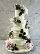 pink-combed-buttercream-with-a-seection-of-pink-silk-flowers-wedding-cake