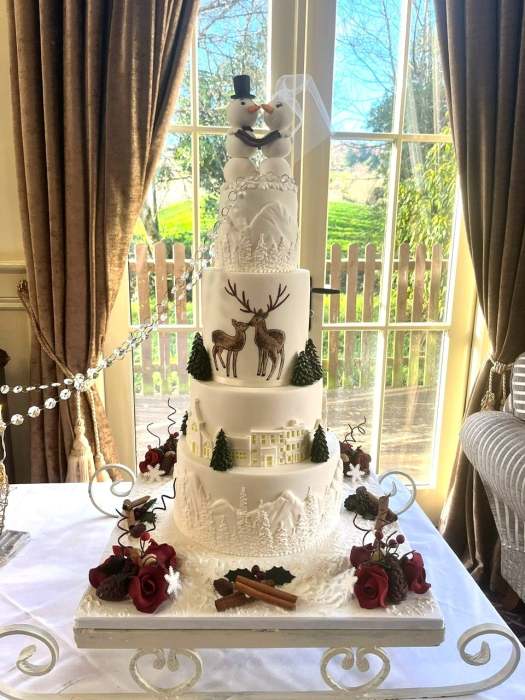 Winter wedding cake design with Alpine scenes and hand painted Deer