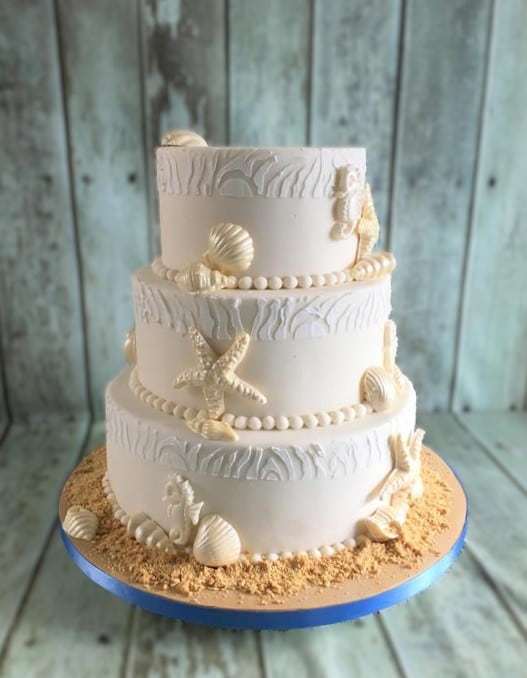 seaside design wedding cake with edible sand and seashells