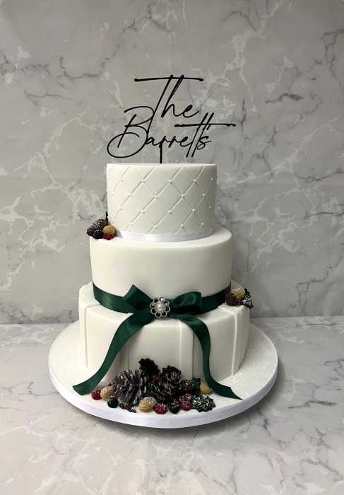 Winter  wedding cake with acorns , berries and a dusting of icing sugar