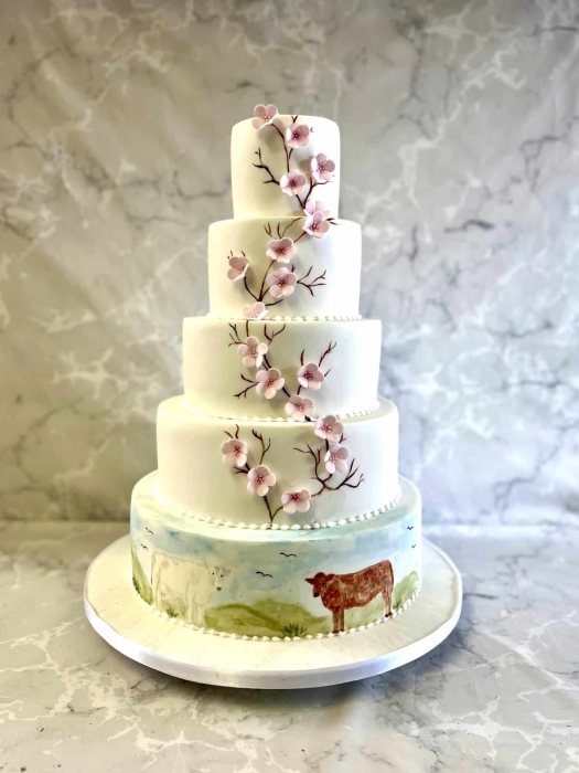 Delicate Cherry blossom wedding cake and hand painted farming scene