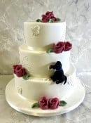 Vintage lace wedding cake with sugar dog eating into the cake 