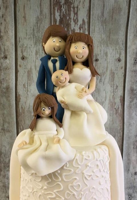 sugar bride and groom wedding cake topper holding baby
