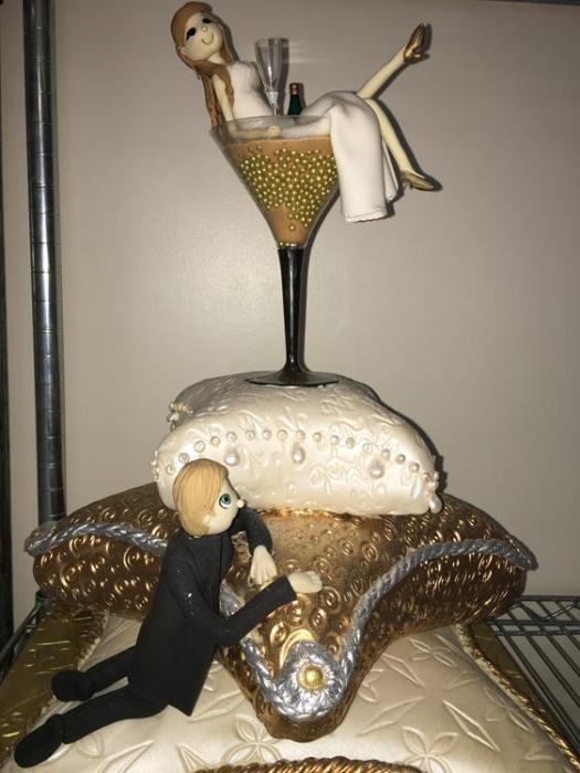 bride in a glasss and groom made in sugar wedding cake topper