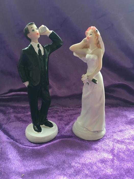 wedding cake topper bride and groom on their phones