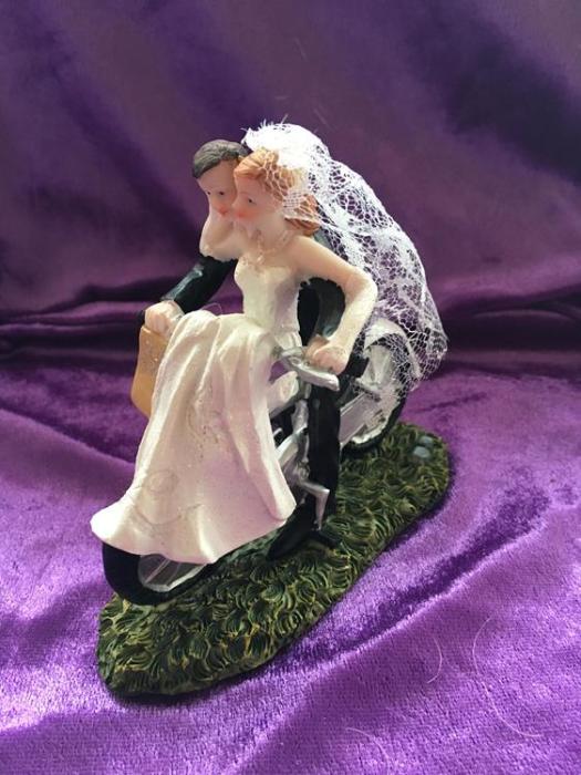 bride and groom on a push bike wedding cake topper