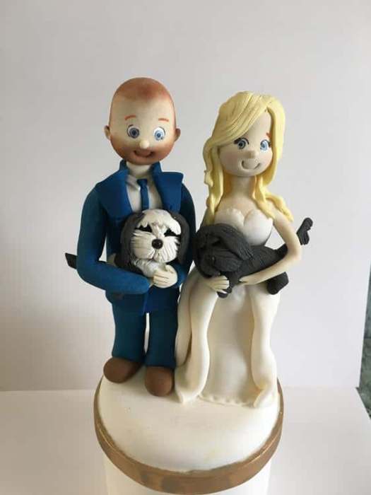 sugar bride and groom wedding cake topper holding dogs