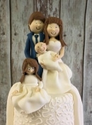 sugar bride and groom wedding cake topper holding baby