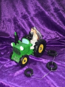 bride and groom in green tractor wedding cake topper