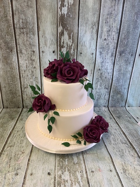 2-tier- white iced-wedding-cake-with-silk-red-roses