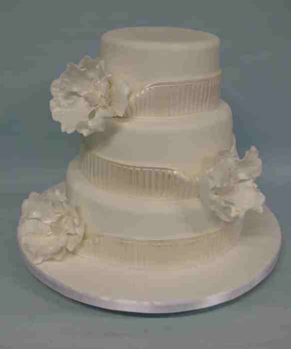wedding cake with sashes and flowers