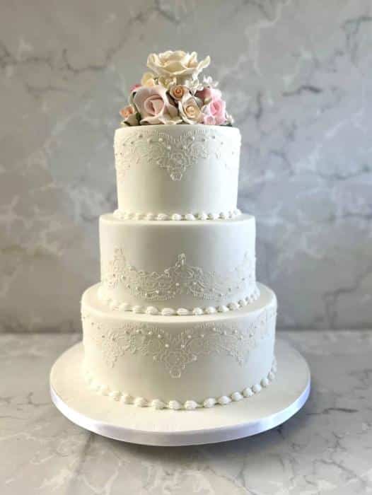 Delicate ace with hand piped pearls finished off with sugar flowers