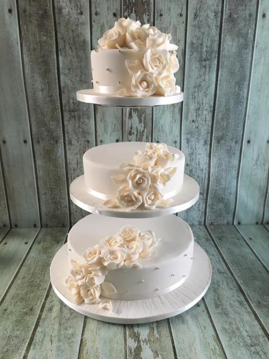 Wedding cake on a stand with sugar roses