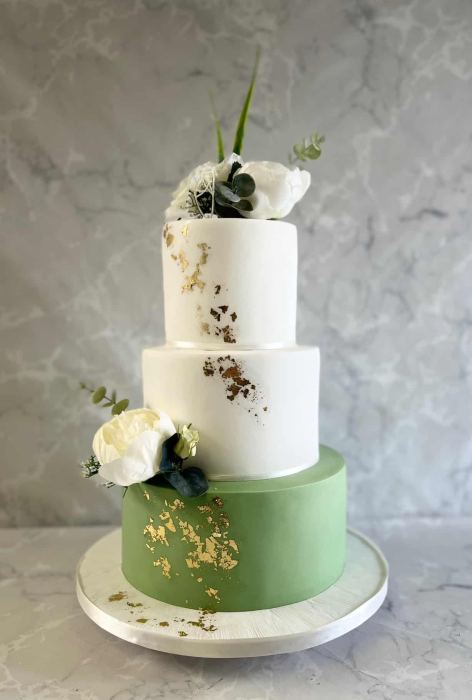 ced wedding cake with silk flowers and sage green base with gold leaf