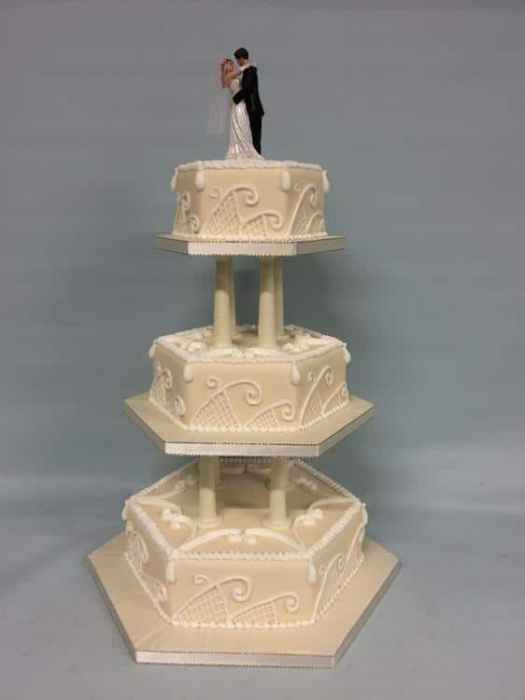 Regal hexagonal hand piped wedding cake on pillars