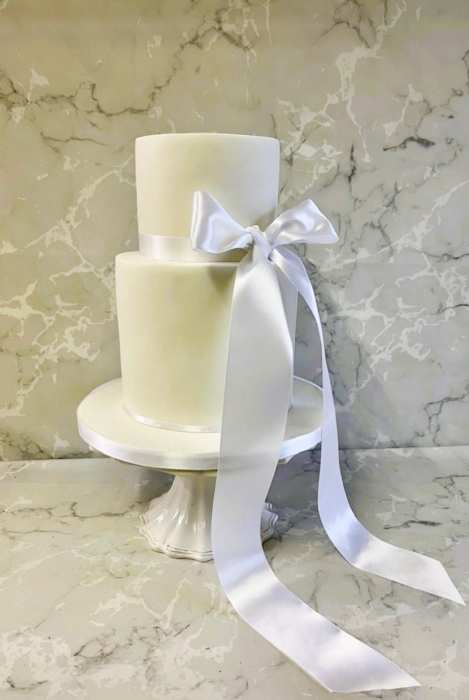 Elegant tall wedding cake with white satin bow