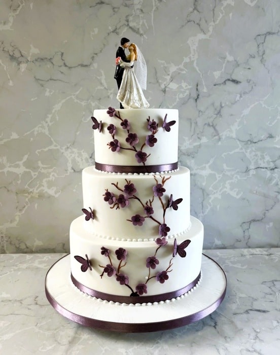 Purple and white wedding cake with sugar delicate blossoms