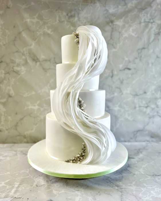 Wave of sugar paper and edible pearls wedding cake