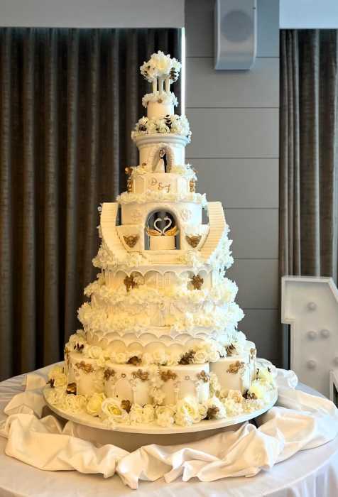 Extra large wedding cake with sugar decorations and silk flowers