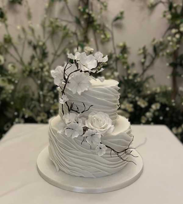 White-wedding-cake-with-icing-flowers-and-Twigs