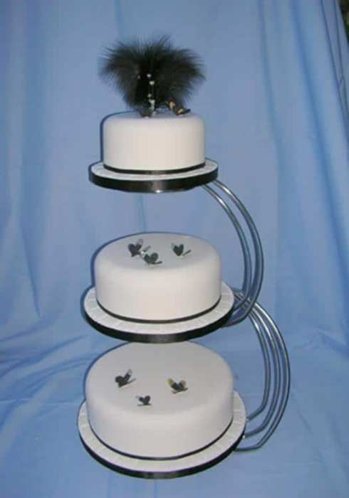 Round wedding cake on a stand with feathers and butterflys