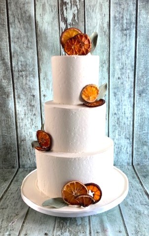 frosting wedding cake with dried oranges