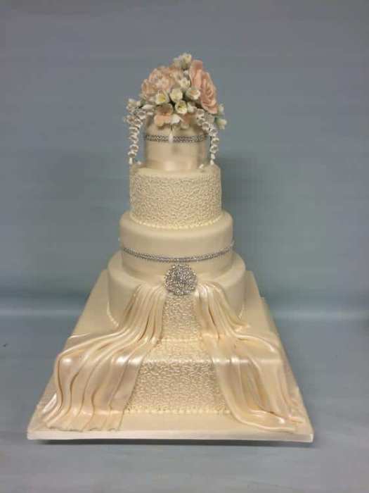 elegant wedding cake with round and square tiers white with swags